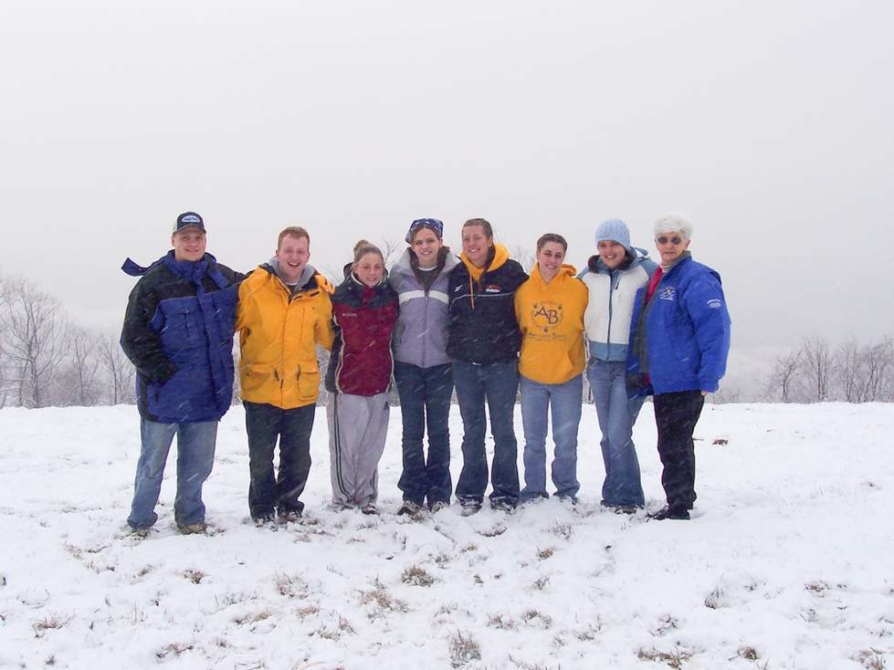 Group of students standing in light snow.